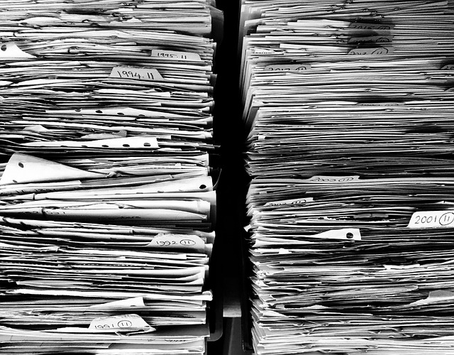 Stacks of old paper invoices and documents — the manual way